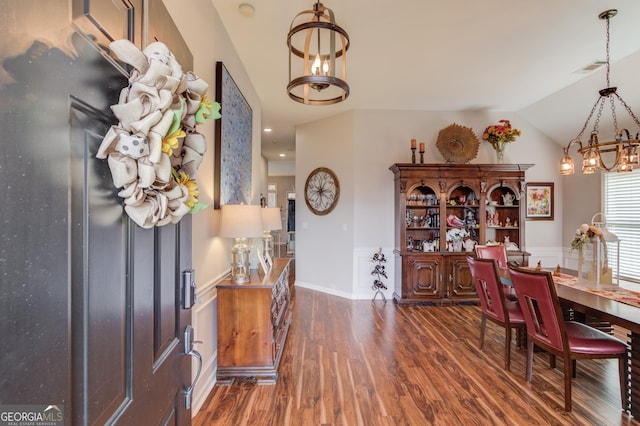 dining area featuring vaulted ceiling and dark hardwood / wood-style floors