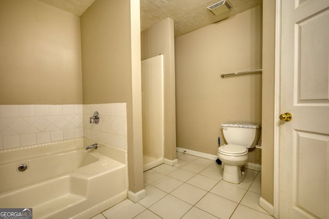 bathroom with a textured ceiling, a bathtub, tile patterned flooring, and toilet