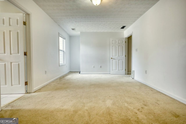 carpeted spare room with a textured ceiling