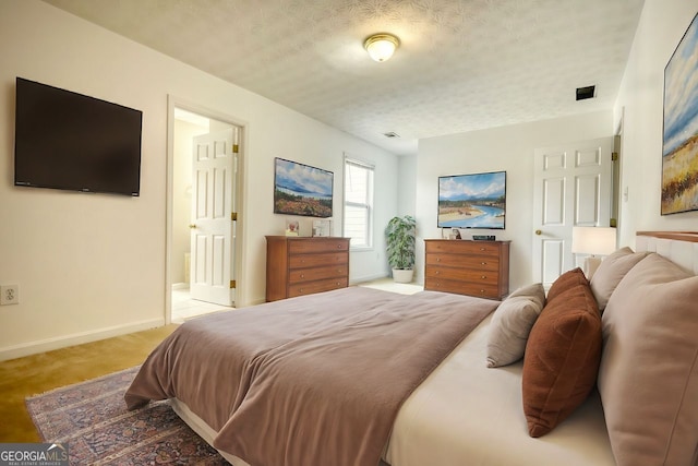 bedroom featuring light colored carpet and a textured ceiling