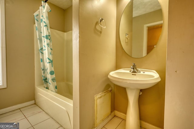 bathroom featuring shower / tub combo with curtain, a textured ceiling, and tile patterned floors