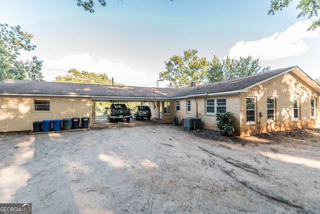 ranch-style home featuring central AC and a carport