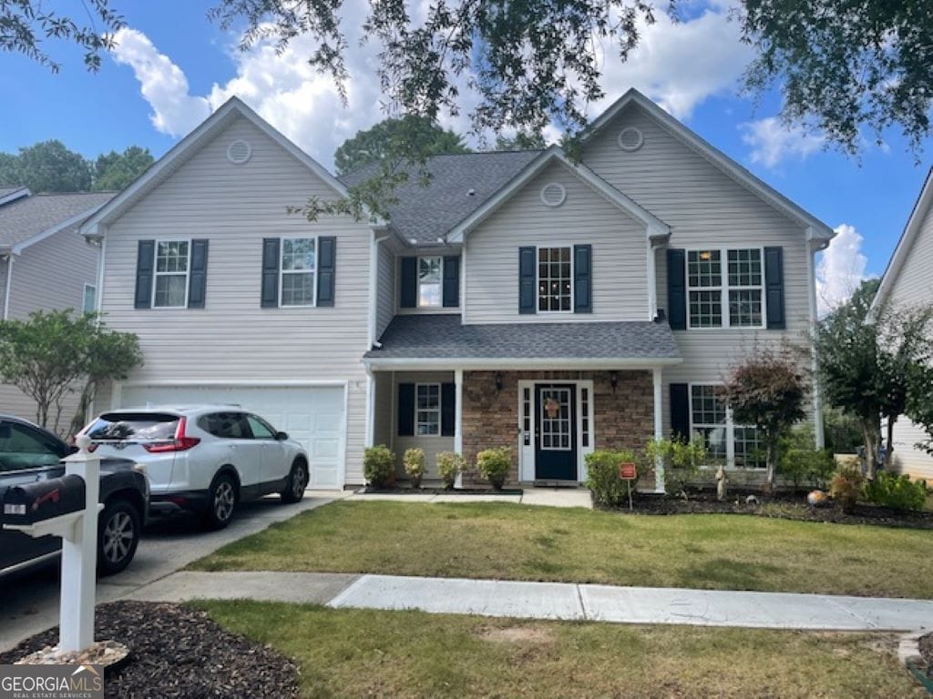 front of property with a garage and a front lawn