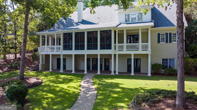 exterior space featuring a balcony and a front lawn