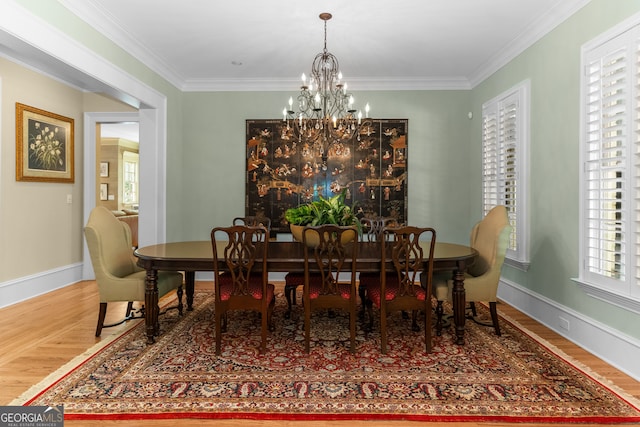 dining room featuring an inviting chandelier, hardwood / wood-style flooring, and crown molding