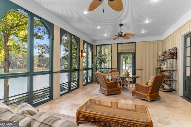 sunroom / solarium with a water view, ceiling fan, and a healthy amount of sunlight