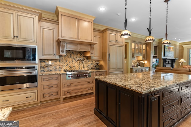 kitchen featuring dark brown cabinetry, pendant lighting, appliances with stainless steel finishes, and light wood-type flooring