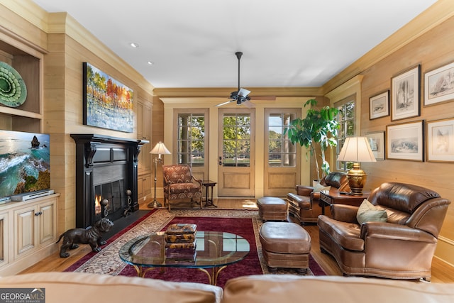 living room featuring crown molding, ceiling fan, and hardwood / wood-style flooring