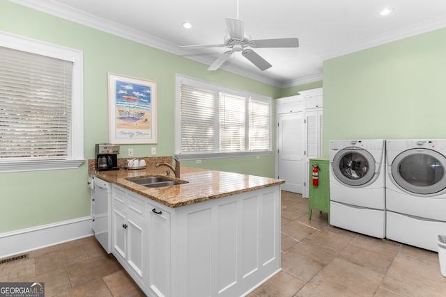 clothes washing area featuring light tile patterned flooring, sink, washer and dryer, crown molding, and ceiling fan