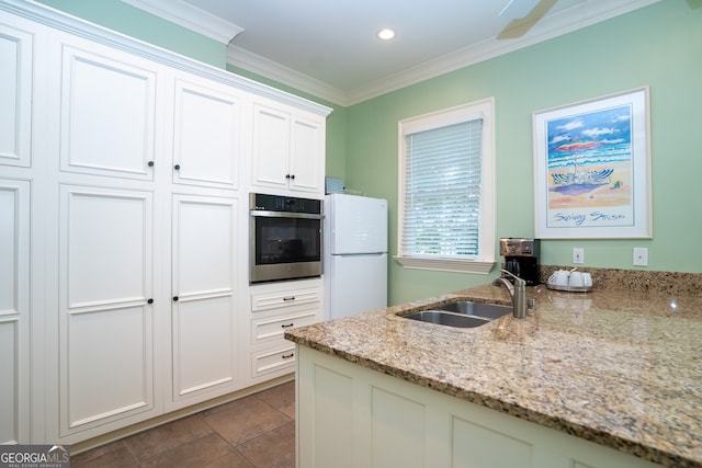 kitchen with sink, white fridge, ornamental molding, stainless steel oven, and light stone countertops