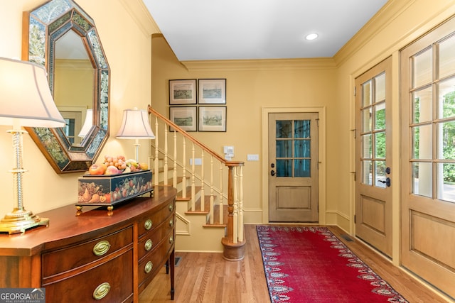 foyer featuring ornamental molding and hardwood / wood-style floors