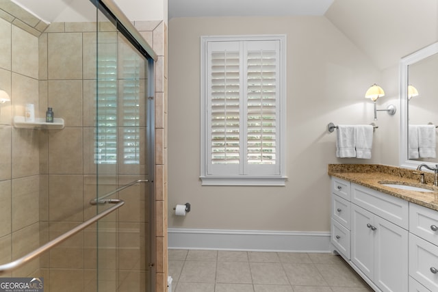 bathroom featuring vanity, lofted ceiling, a shower with shower door, and tile patterned flooring