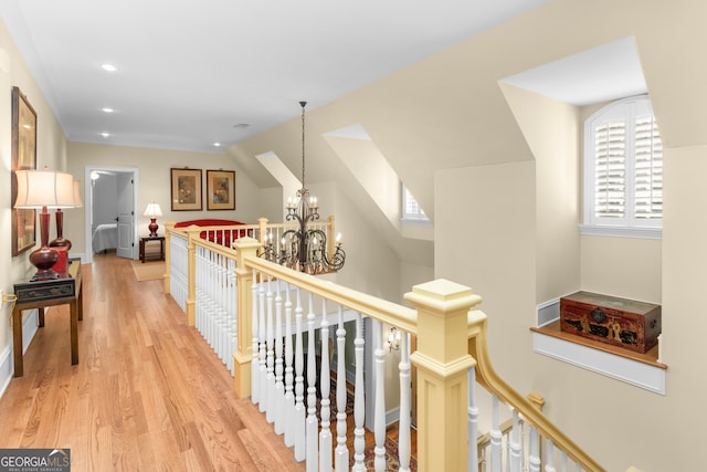 hall featuring vaulted ceiling, an inviting chandelier, and light hardwood / wood-style flooring