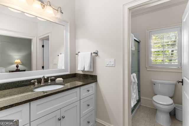 bathroom with vanity, toilet, tile patterned floors, and a shower with shower door