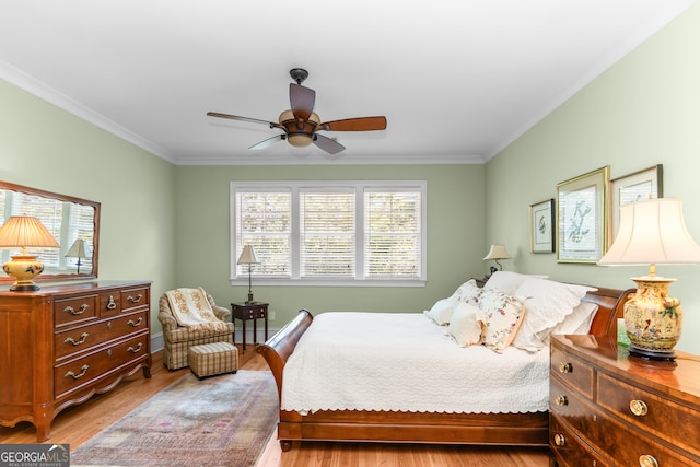 bedroom featuring ceiling fan, light hardwood / wood-style flooring, crown molding, and multiple windows