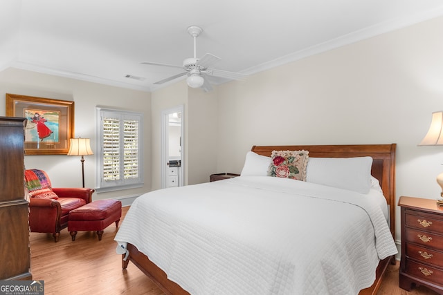 bedroom with ornamental molding, ensuite bath, ceiling fan, and hardwood / wood-style floors