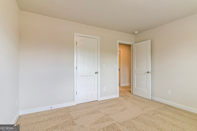 unfurnished bedroom featuring light carpet