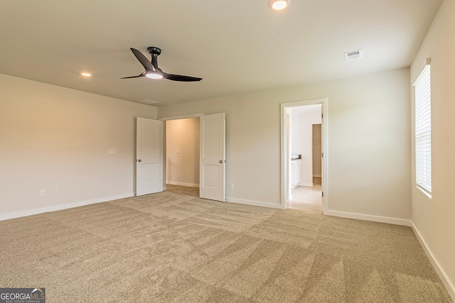 unfurnished bedroom with ceiling fan, light colored carpet, and multiple windows