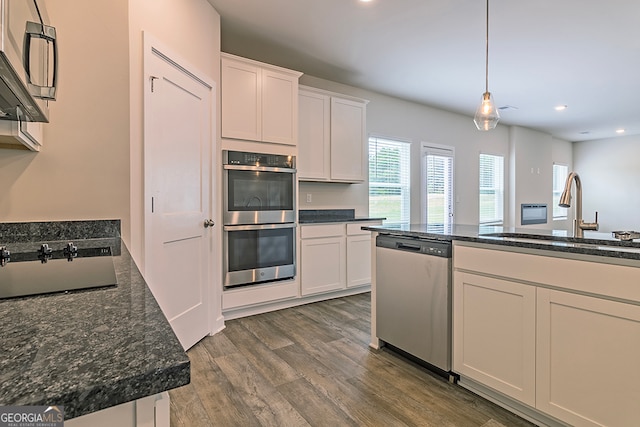 kitchen with stainless steel appliances, dark wood-type flooring, sink, and white cabinetry