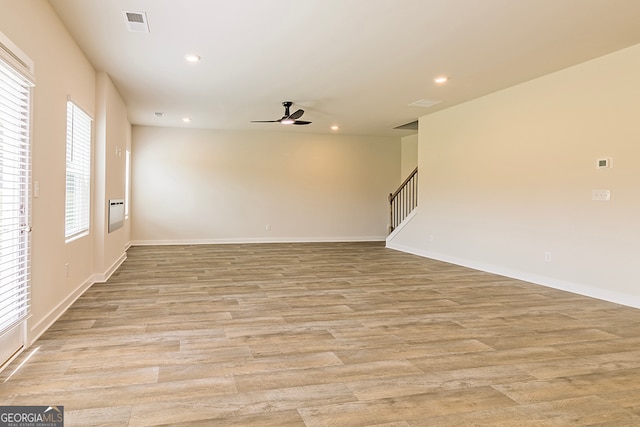 spare room with light wood-type flooring, a healthy amount of sunlight, and ceiling fan