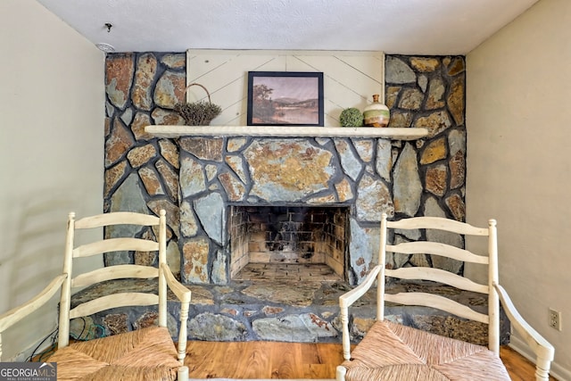 room details featuring wood-type flooring, a textured ceiling, and a fireplace