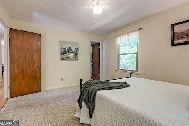 bedroom with ceiling fan, carpet floors, and a textured ceiling