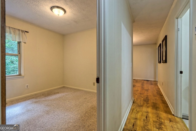 hallway featuring dark wood-type flooring and a textured ceiling