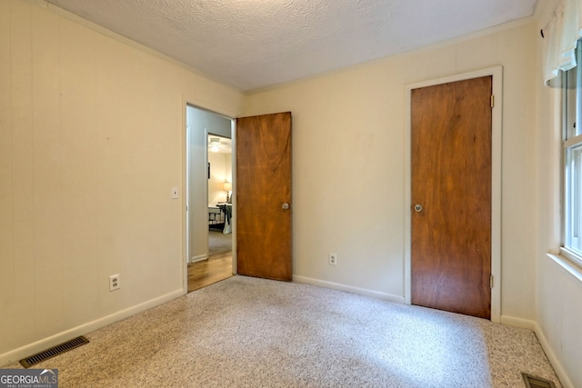 unfurnished bedroom featuring a textured ceiling and a closet