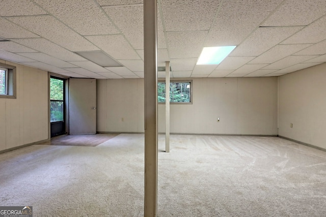 basement featuring a drop ceiling and light carpet