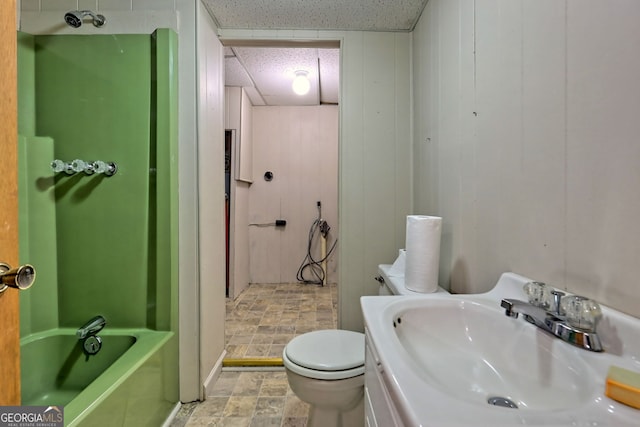 bathroom featuring wooden walls, vanity, and toilet