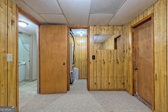 hallway with light colored carpet and wooden walls