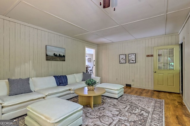 living room featuring wood-type flooring and wooden walls