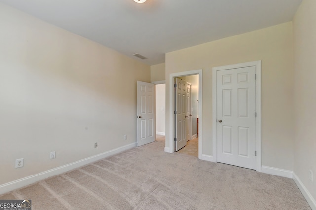 unfurnished bedroom featuring light carpet