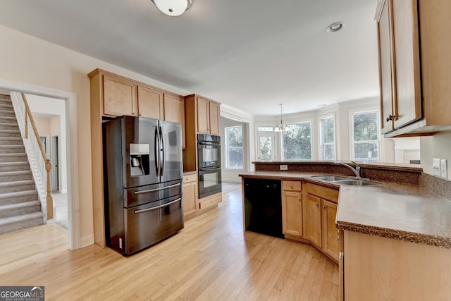 kitchen with pendant lighting, sink, black appliances, an inviting chandelier, and light wood-type flooring