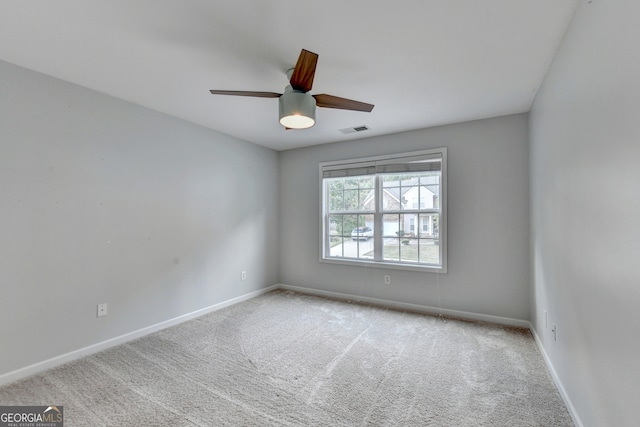 carpeted spare room with ceiling fan