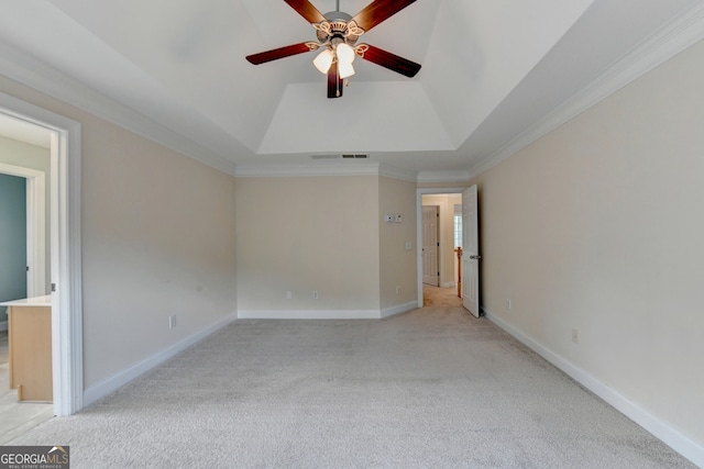 spare room featuring ceiling fan, lofted ceiling, a tray ceiling, light carpet, and crown molding