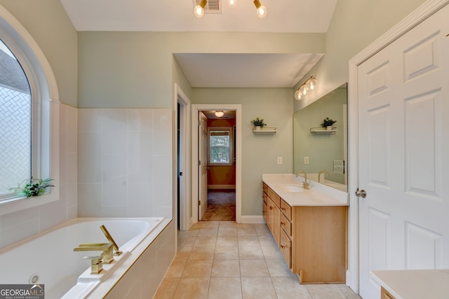 bathroom with vanity, tile patterned floors, and a relaxing tiled tub