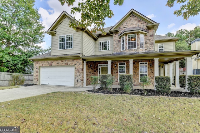 view of front of home with a garage, a front lawn, and covered porch