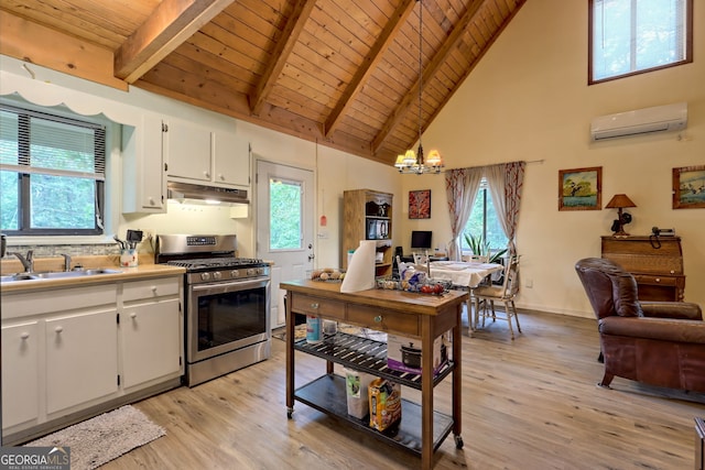 kitchen featuring sink, white cabinetry, hanging light fixtures, stainless steel gas stove, and a wall mounted AC