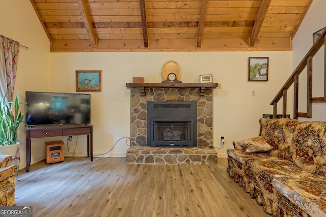 living room with wooden ceiling, vaulted ceiling with beams, a stone fireplace, and hardwood / wood-style floors