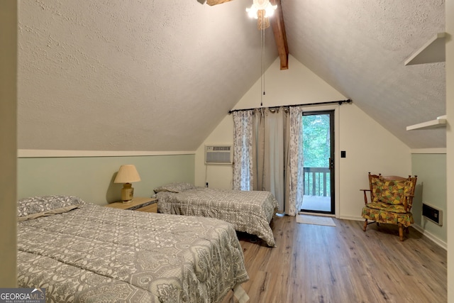 bedroom featuring lofted ceiling with beams, access to exterior, a textured ceiling, a wall unit AC, and hardwood / wood-style flooring