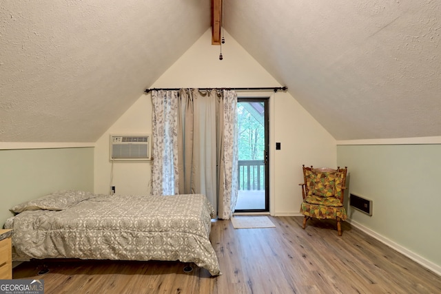 bedroom with access to outside, light hardwood / wood-style flooring, lofted ceiling with beams, and a wall mounted air conditioner