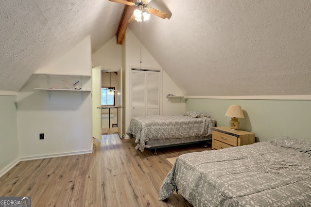 bedroom featuring lofted ceiling with beams, a closet, light wood-type flooring, a textured ceiling, and ceiling fan