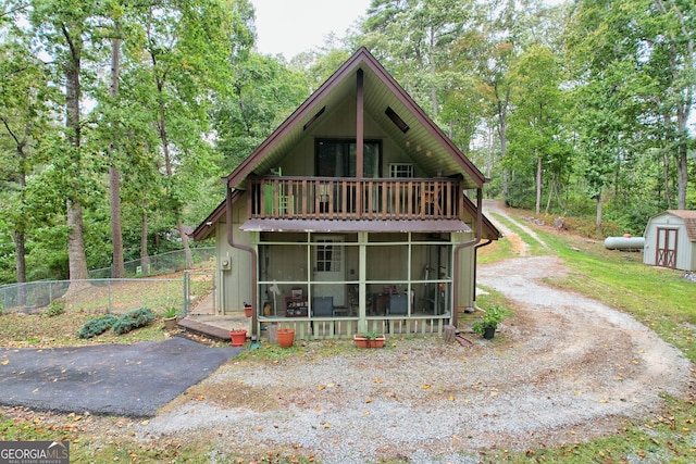 view of front of property with a sunroom and a shed