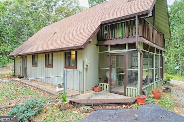 back of house featuring a balcony and a sunroom