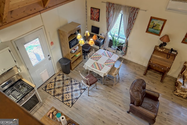 interior space with a wall unit AC, light hardwood / wood-style flooring, and a healthy amount of sunlight