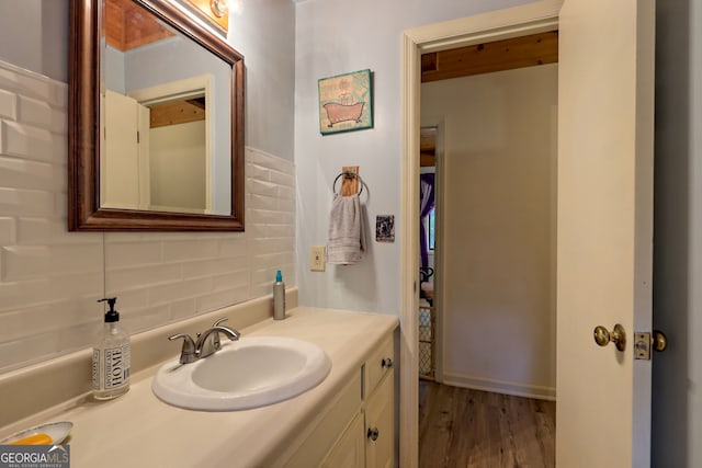 bathroom with decorative backsplash, hardwood / wood-style flooring, and vanity