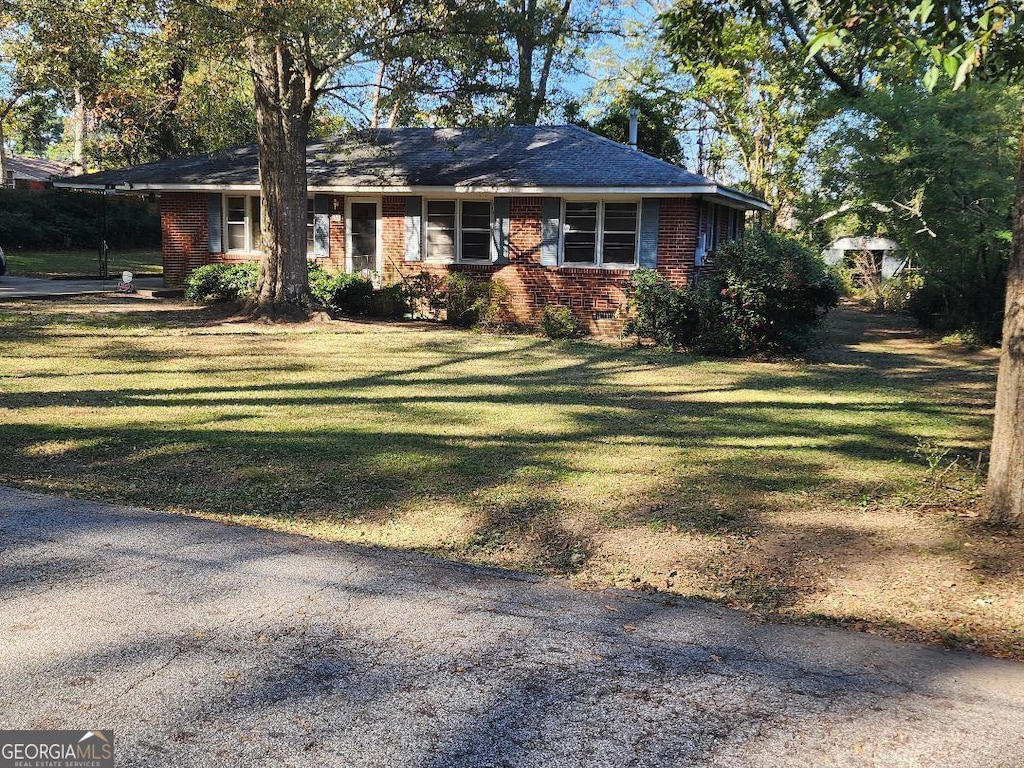 ranch-style home featuring a front lawn