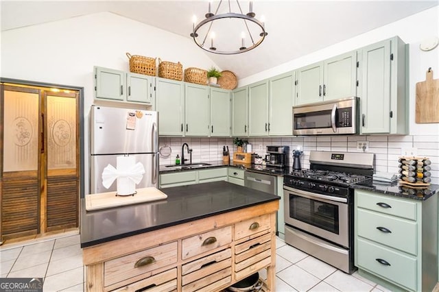 kitchen featuring light tile patterned floors, stainless steel appliances, vaulted ceiling, and a sink