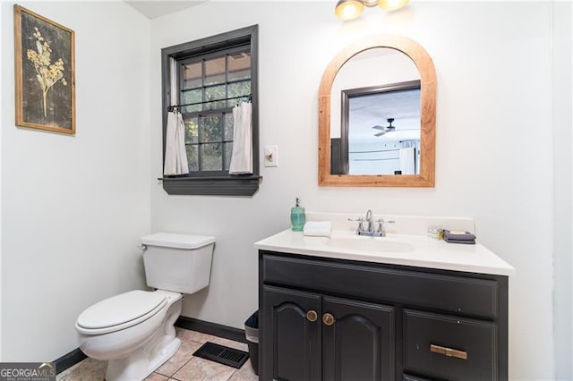 half bath featuring tile patterned flooring, toilet, visible vents, vanity, and baseboards